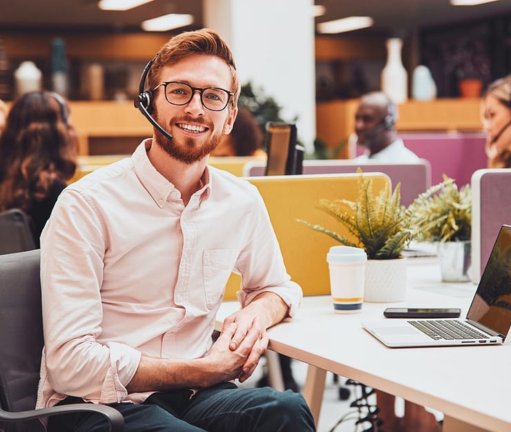 Retrato de empresário usando fone de ouvido falando com o chamador no centro de atendimento ao cliente